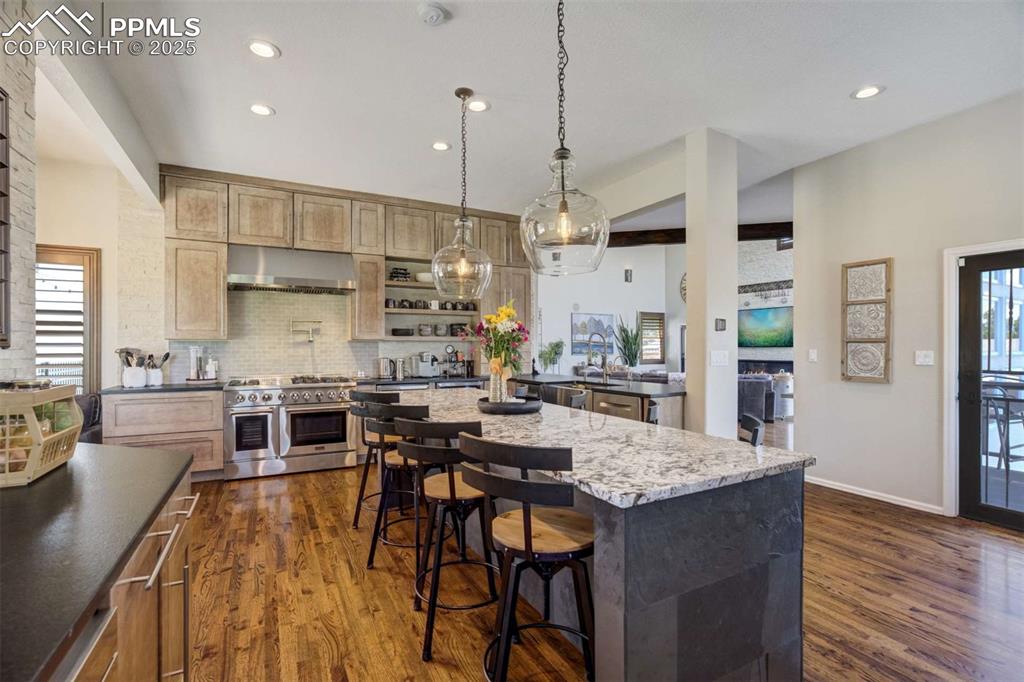 Image 12 of 50: Kitchen with healthy amount of natural light, dark wood-type flooring, doub