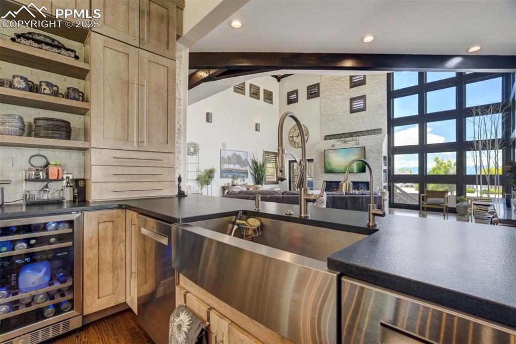Image 16 of 50: Kitchen with beverage cooler, high vaulted ceiling, open floor plan, beam c