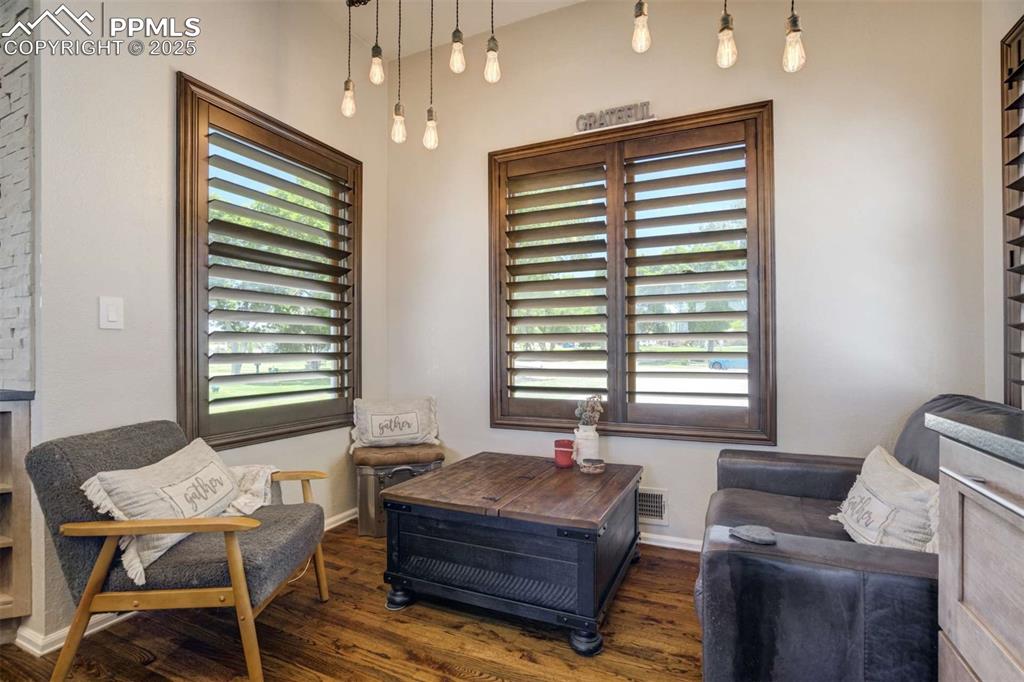 Image 17 of 50: Living area with dark wood-style flooring