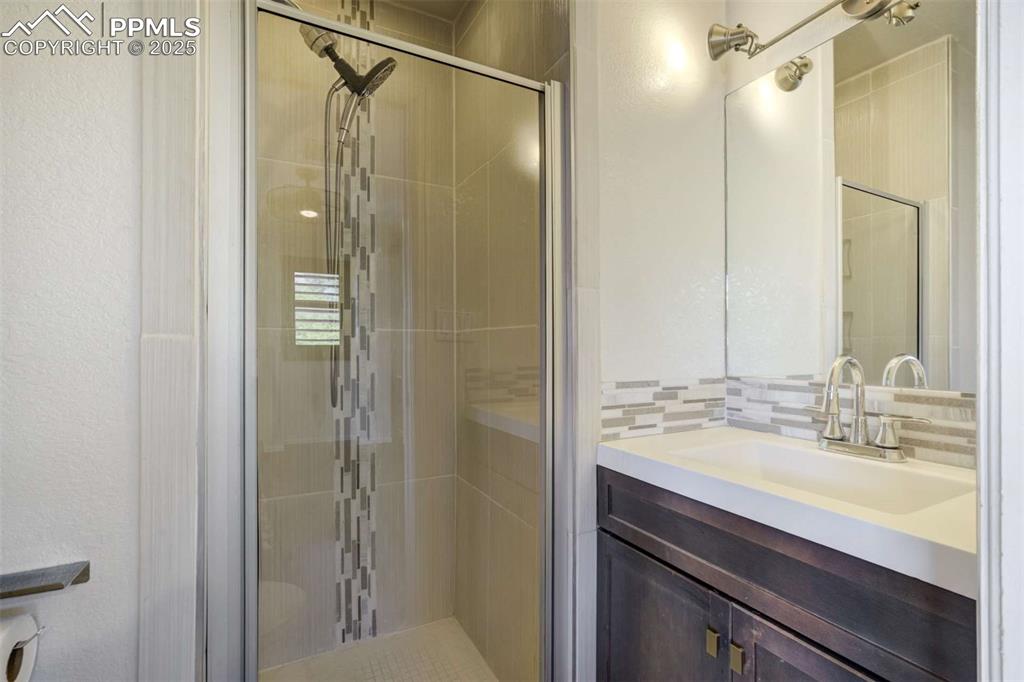Image 25 of 50: Full bathroom with vanity and a shower stall