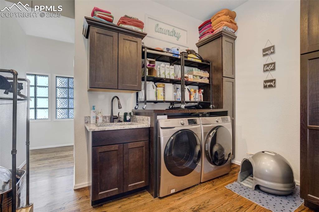 Image 28 of 50: Washroom featuring light wood-style floors, washing machine and clothes dry