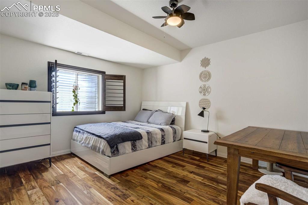 Image 35 of 50: Bedroom with wood finished floors and ceiling fan