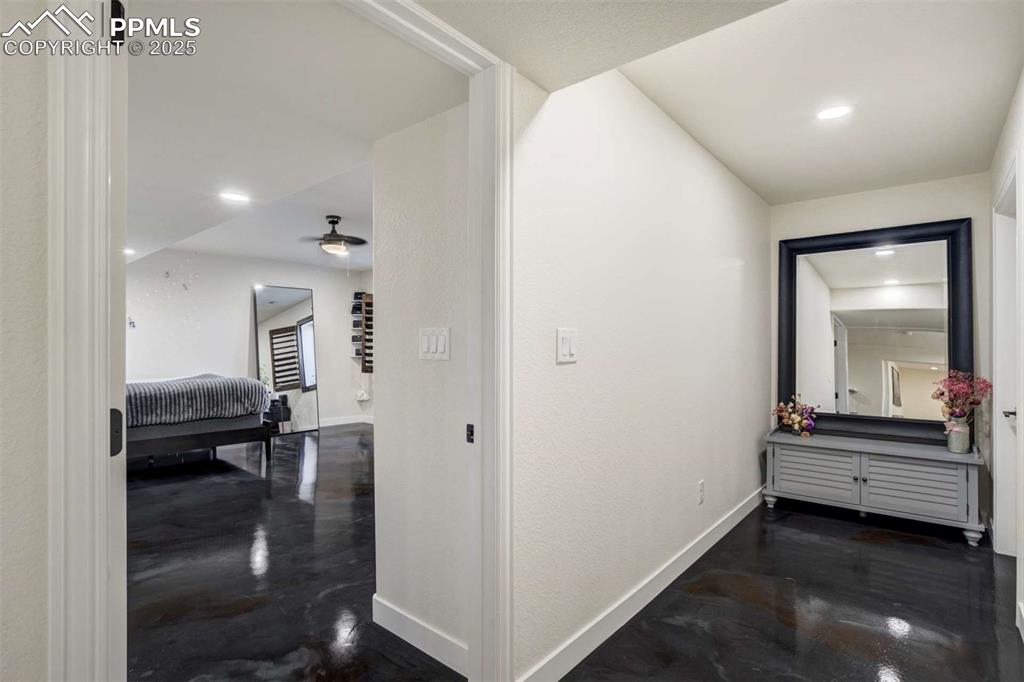 Image 36 of 50: Hallway featuring finished concrete flooring and recessed lighting