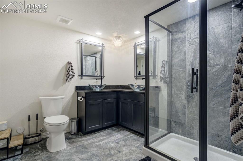 Image 38 of 50: Full bath featuring a stall shower, double vanity, recessed lighting, and a