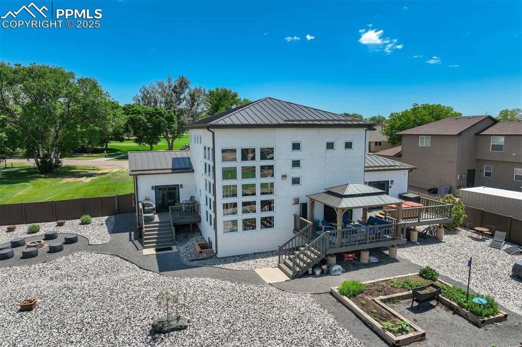 Image 43 of 50: View of outdoor structure with a gazebo, stairway, and a vegetable garden