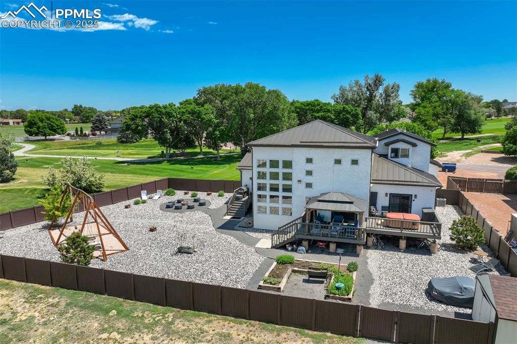 Image 44 of 50: Rear view of house with a fenced backyard, a metal roof, stairs, view of go