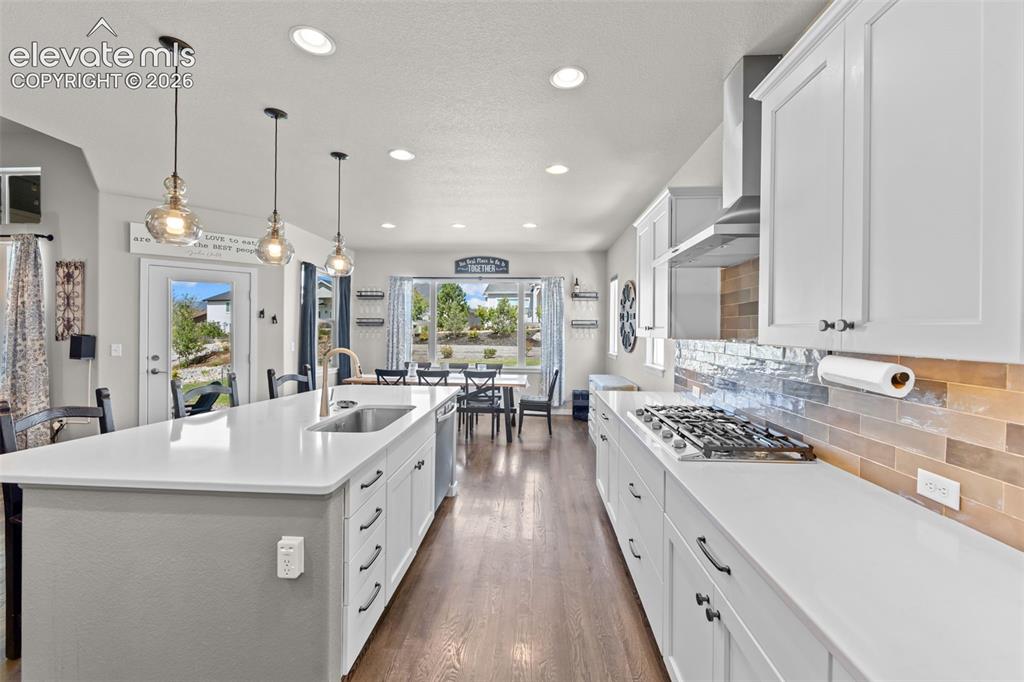 Image 12 of 32: Open-concept kitchen featuring an expansive island with an undermount sink,
