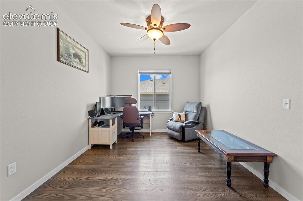 Image 14 of 32: Room with wood-finish flooring, a ceiling fan, and a window with blinds