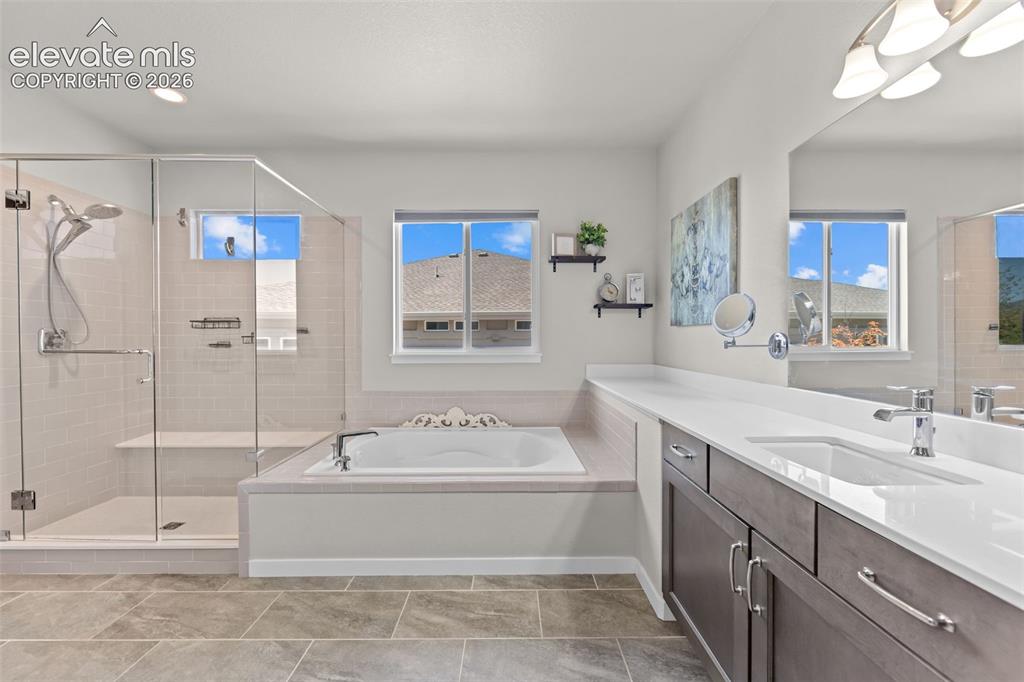 Image 17 of 32: Spacious bathroom with a walk-in glass shower, built-in soaking tub, dual b
