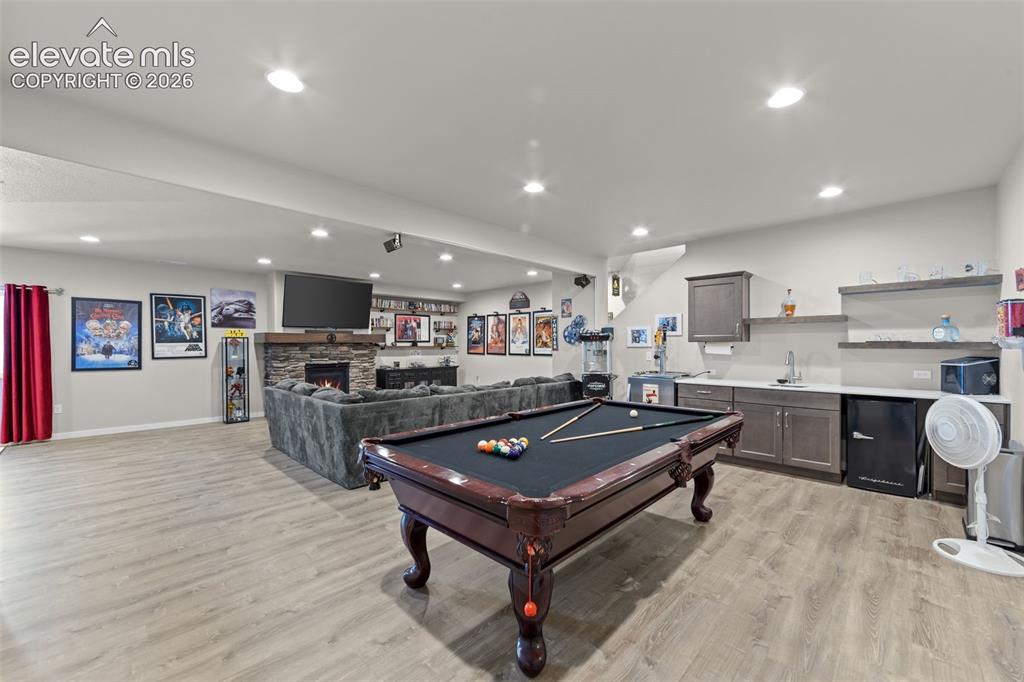 Image 19 of 32: Spacious recreation room featuring light wood-finish flooring, recessed lig