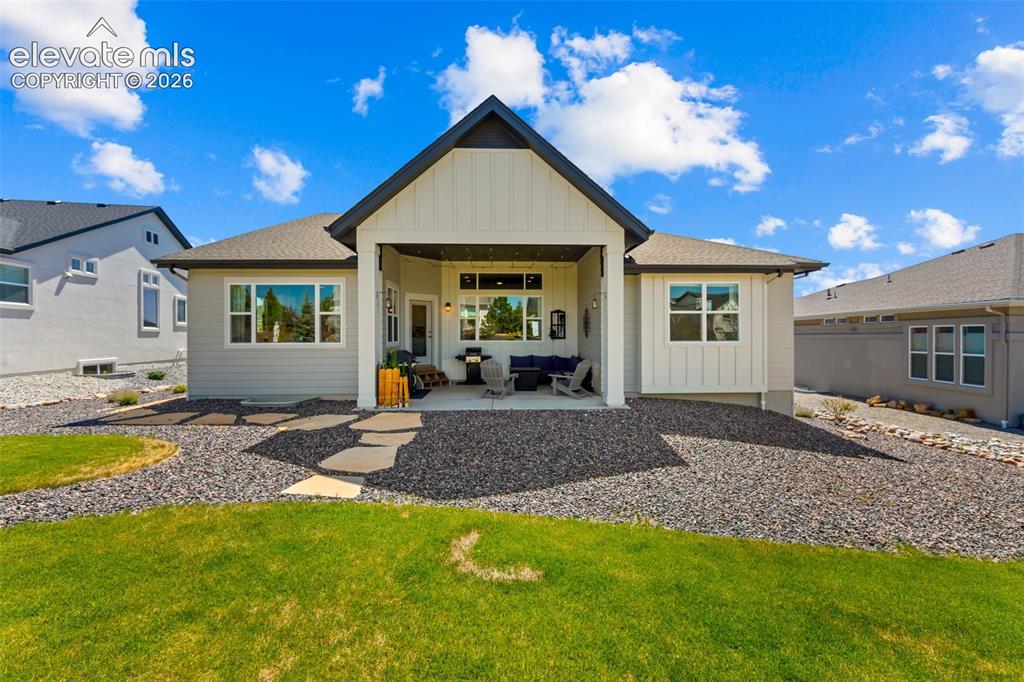Image 25 of 32: Contemporary rear exterior featuring an expansive covered patio, a manicure