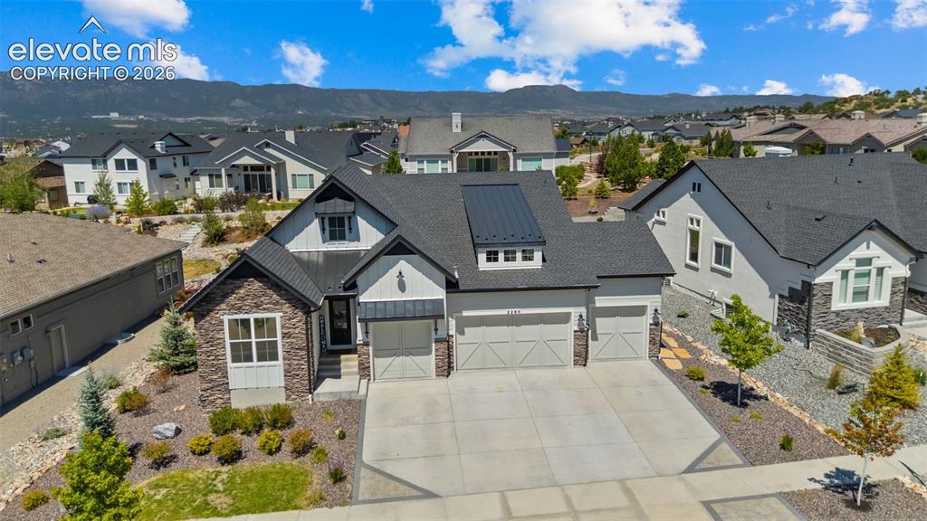 Image 3 of 32: Contemporary residence featuring a stone and siding exterior, a three-car g