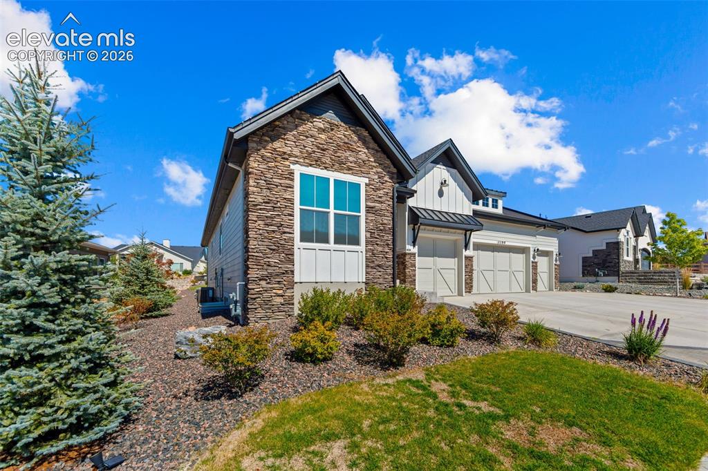 Image 7 of 32: Contemporary residence featuring a stone and siding exterior, a two-car gar