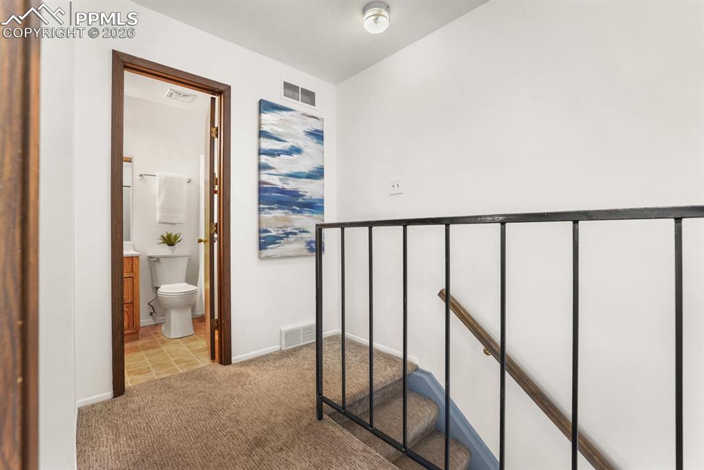 Image 13 of 28: Upper level landing with view into the upper level Full Bathroom.