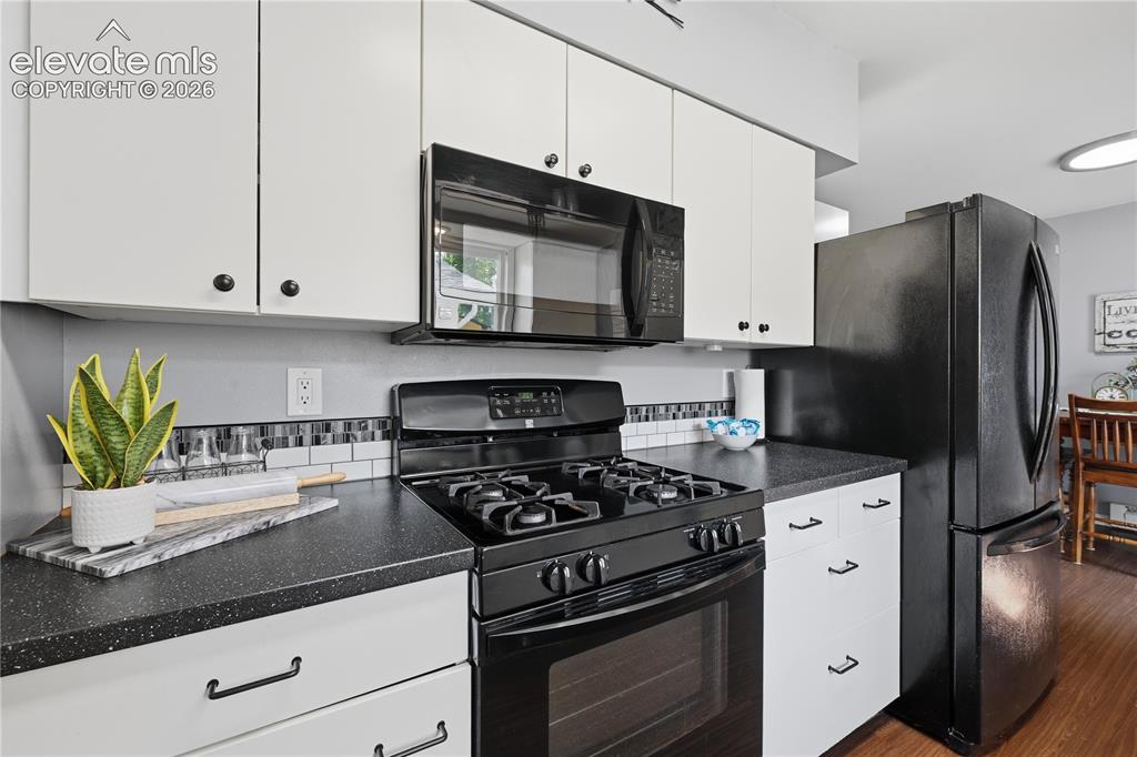 Image 11 of 27: Another view of the kitchen showcases the attractive black appliances, ampl