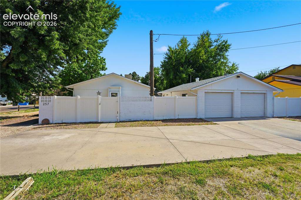 Image 2 of 27: Oversized detached 3 car garage, privacy fencing, and a gated parking area