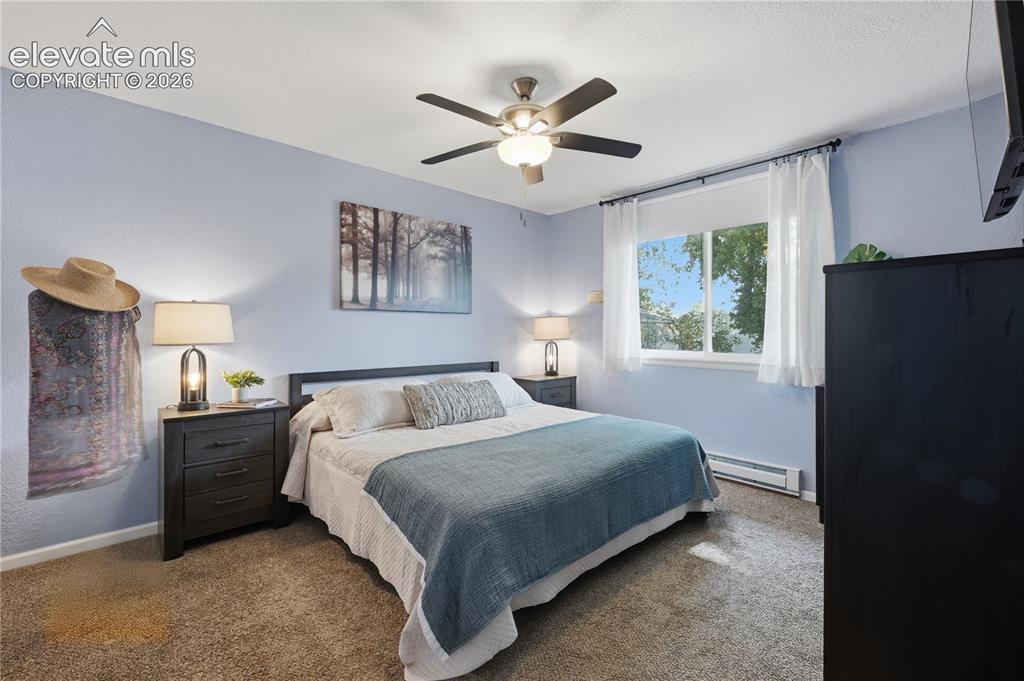 Image 8 of 27: Spacious primary bedroom with neutral finishes, plush carpeting, and plenty