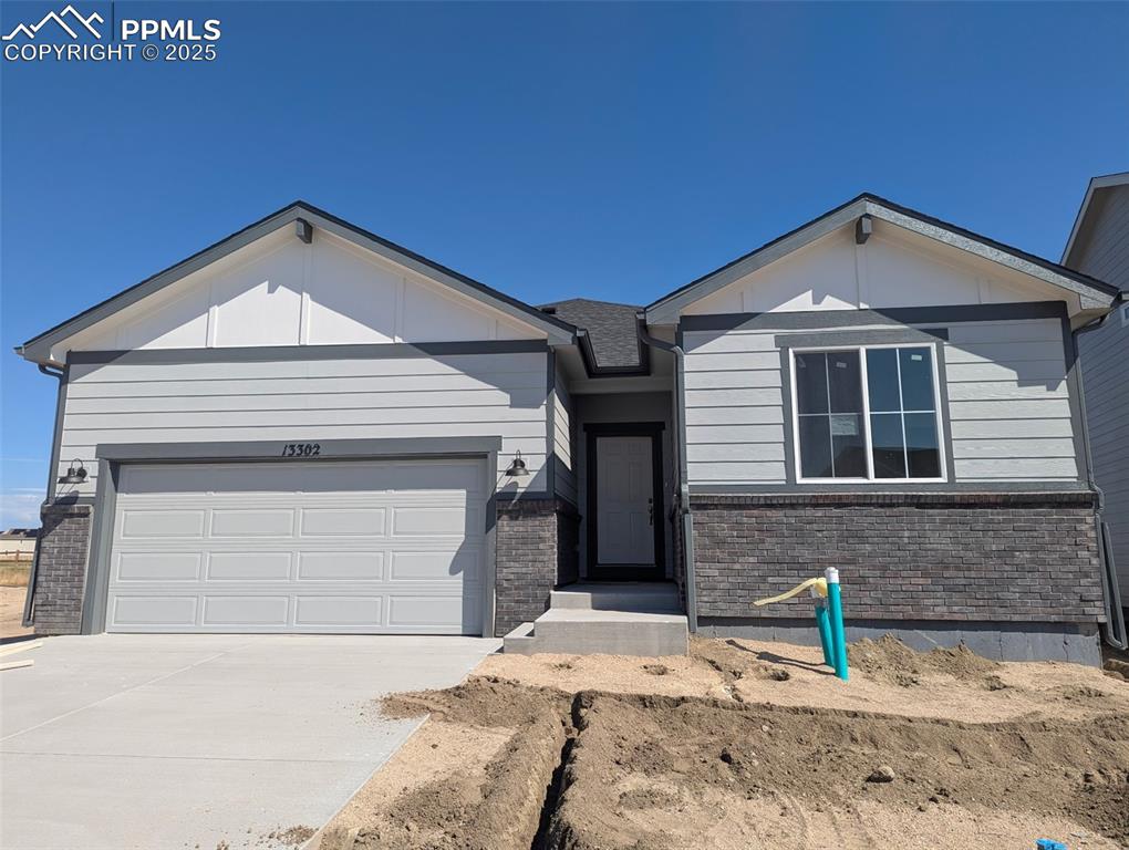 Caption: Single story home with a garage, brick siding, and driveway