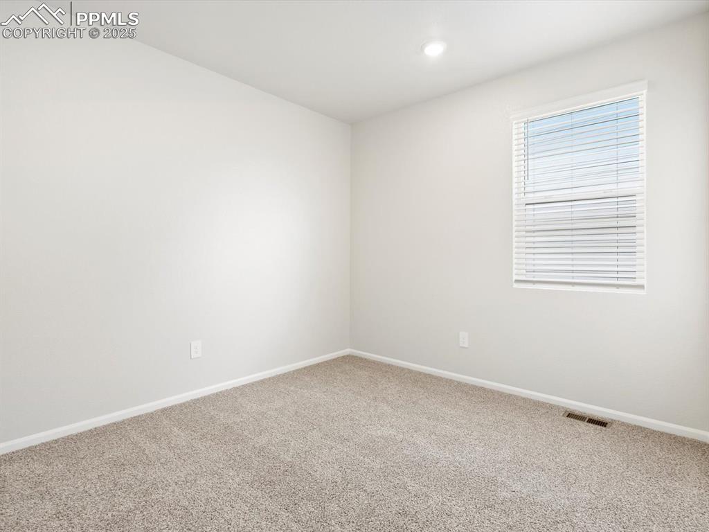 Image 12 of 19: Carpeted spare room featuring baseboards