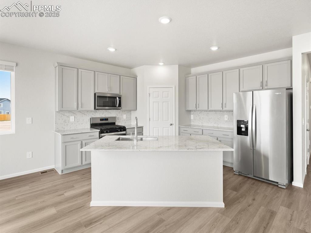 Image 2 of 19: Kitchen featuring appliances with stainless steel finishes, gray cabinetry,
