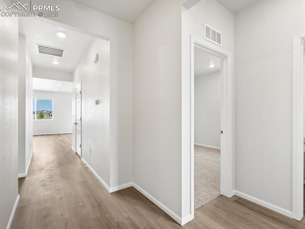 Image 5 of 19: Hall with wood finished floors and recessed lighting
