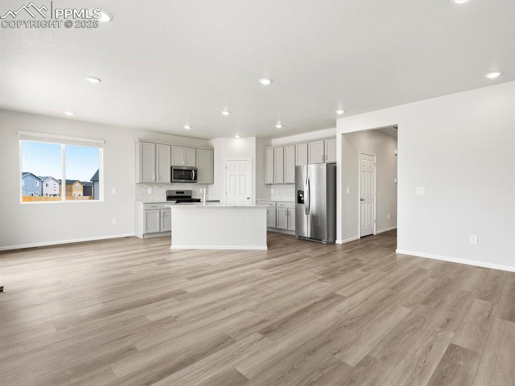Image 6 of 19: Unfurnished living room with light wood-style floors and recessed lighting