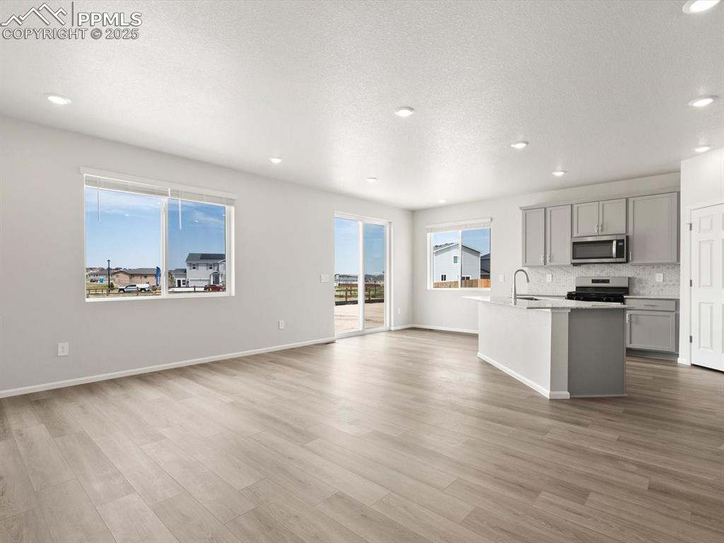 Image 7 of 19: Kitchen featuring gray cabinets, recessed lighting, a kitchen island with s