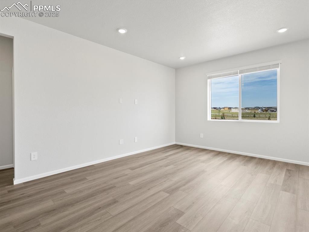 Image 8 of 19: Spare room with wood finished floors and recessed lighting