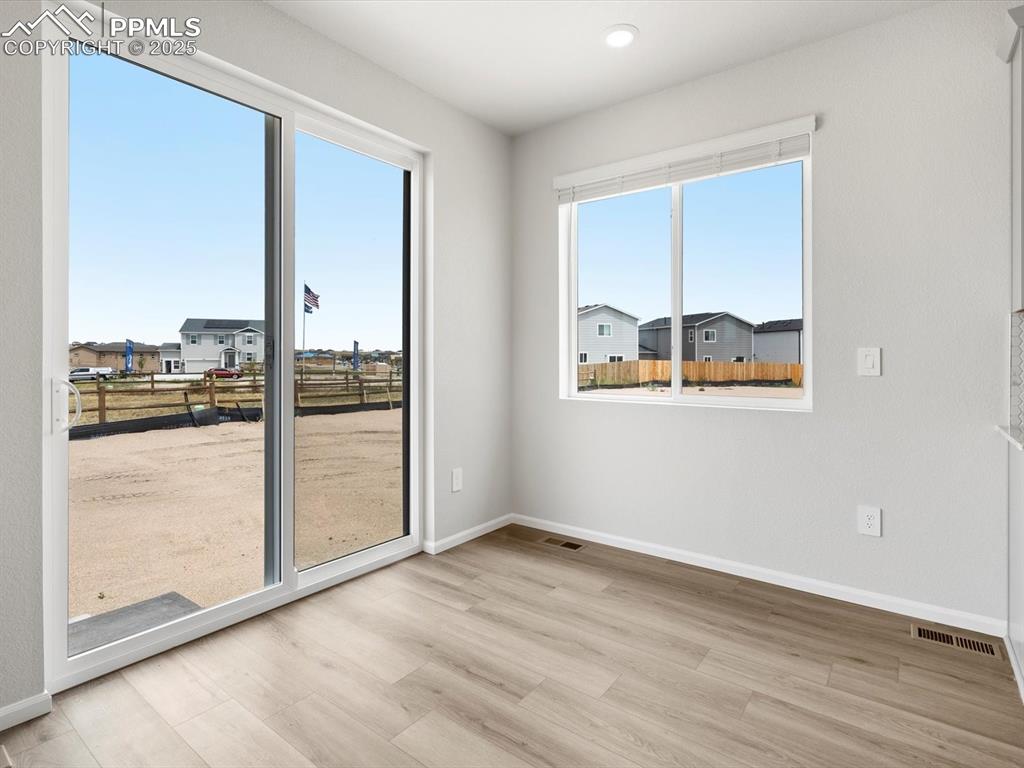 Image 9 of 19: Empty room featuring wood finished floors and a residential view