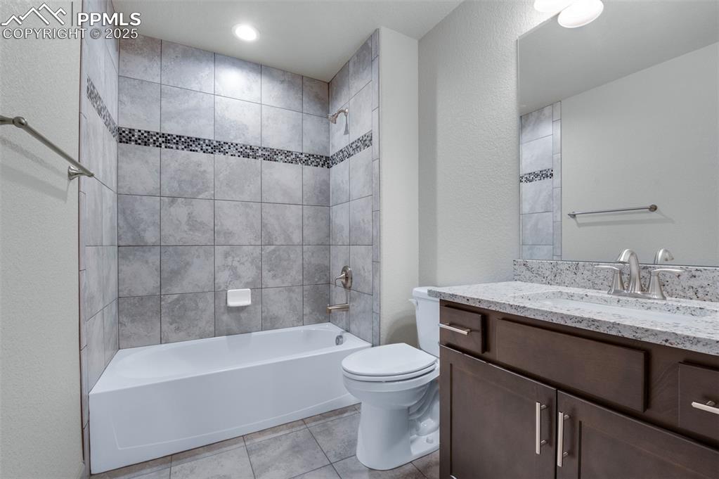 Image 14 of 21: Full bathroom featuring shower / bath combination, vanity, light tile patte