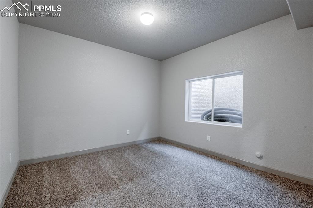 Image 15 of 21: Carpeted empty room featuring a textured ceiling and a textured wall