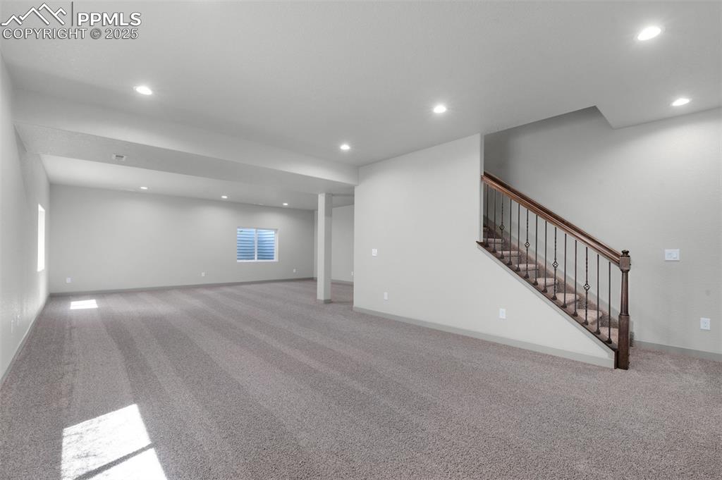 Image 17 of 21: Finished basement with carpet flooring, recessed lighting, and stairway