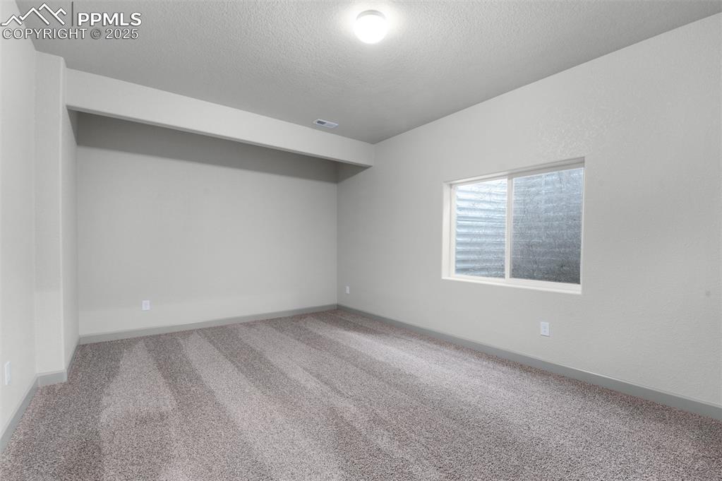 Image 20 of 21: Unfurnished room featuring carpet flooring and a textured ceiling