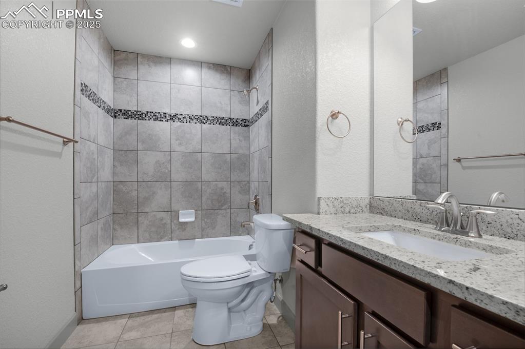 Image 21 of 21: Full bathroom with washtub / shower combination, vanity, a textured wall, a