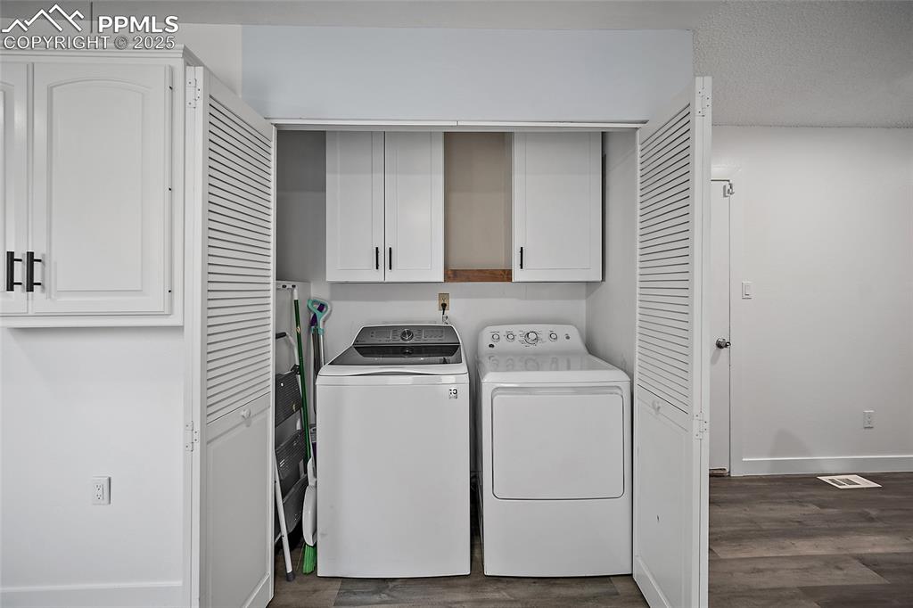 Image 16 of 38: Laundry area with cabinet space, washer & dryer
