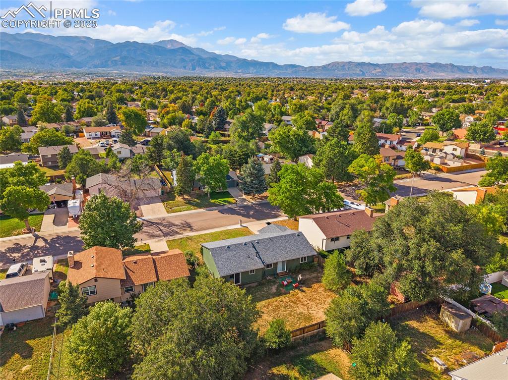 Image 34 of 38: Aerial view of residential area featuring a mountain backdrop