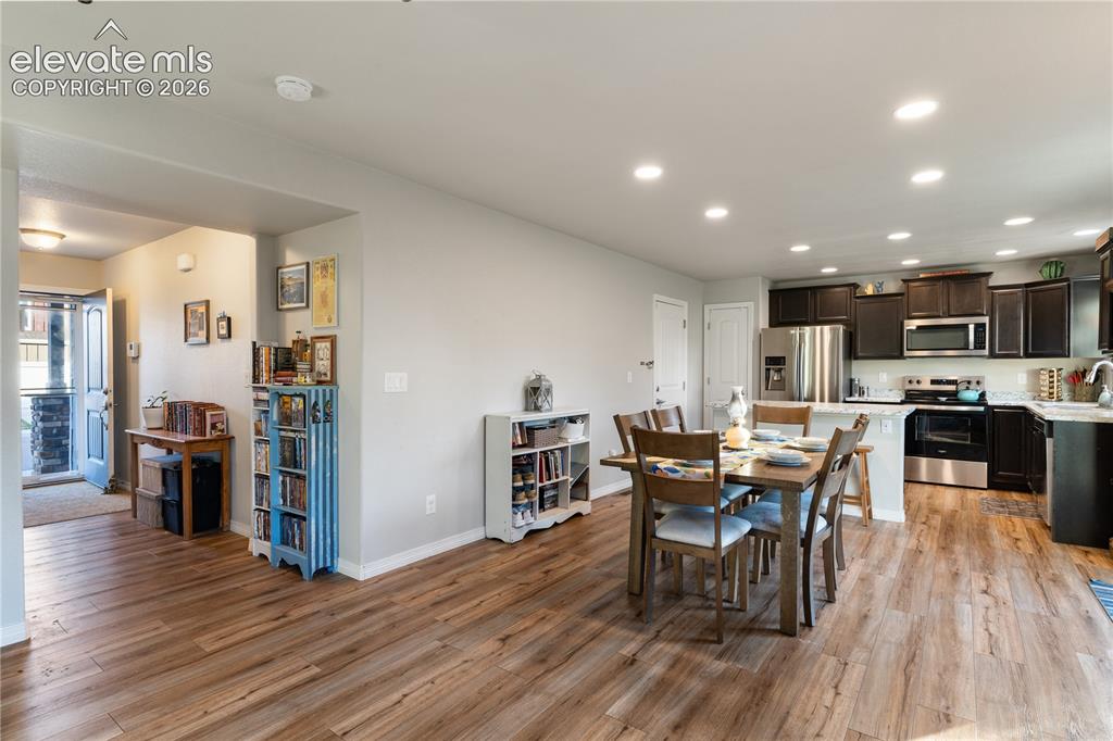 Image 15 of 43: Kitchen and dining area featuring wood-finish flooring