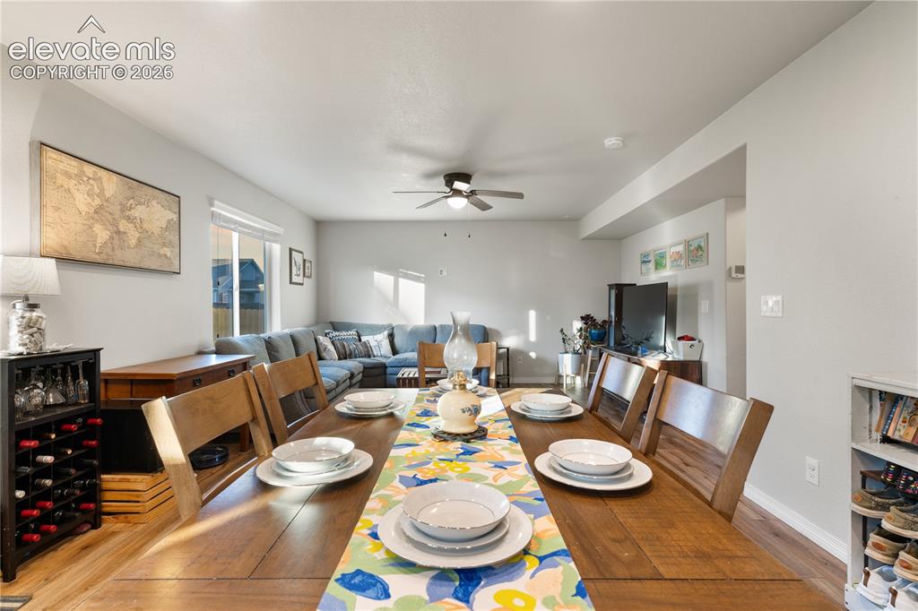 Image 22 of 43: Open-concept dining area featuring wood-finish flooring, a contemporary cei