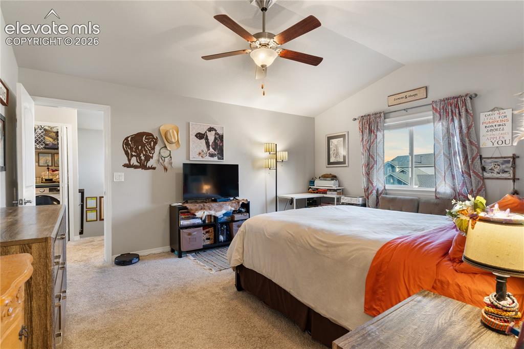 Image 27 of 43: Vaulted ceiling with a ceiling fan, carpet flooring, and a window with a si