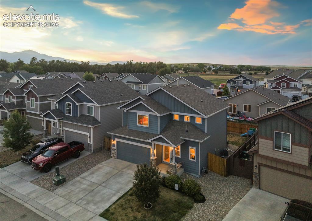 Image 3 of 43: Two-story residence featuring a gray exterior with blue gables, a two-car g