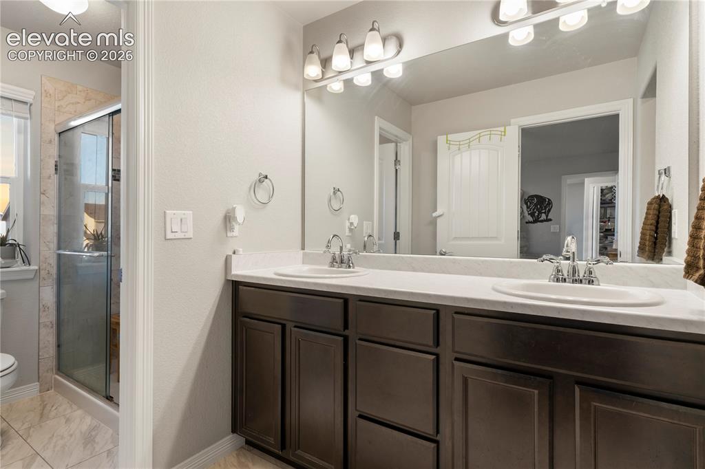 Image 30 of 43: Double vanity, walk in shower, and spacious walk in closet