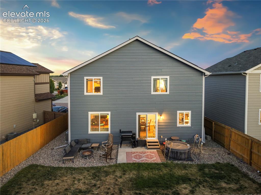 Image 37 of 43: Spacious backyard featuring a concrete patio, gravel landscaping, and a woo