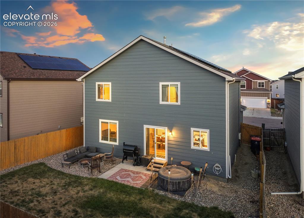 Image 42 of 43: Rear exterior featuring horizontal siding, multiple windows, and a sliding 