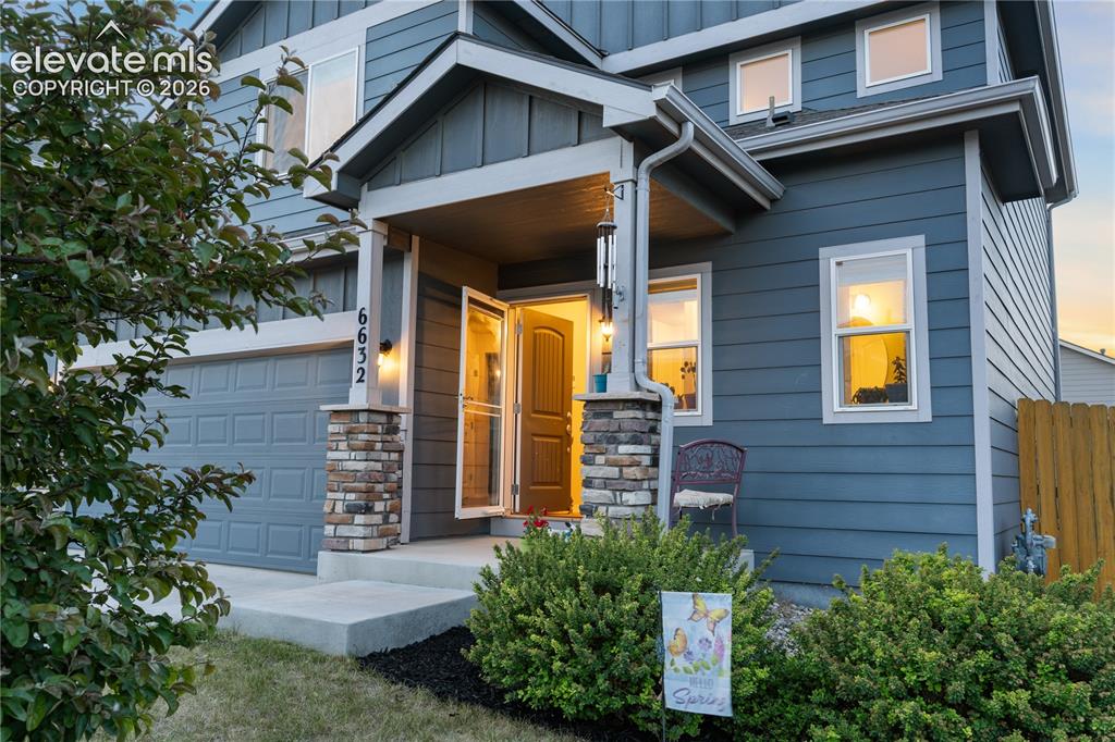 Image 8 of 43: Two-story residence featuring blue horizontal siding and a covered front po