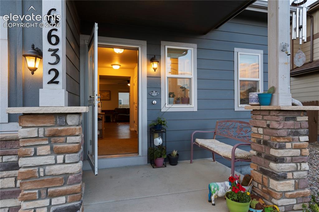 Image 9 of 43: Inviting front entry featuring a concrete porch stacked stone pillar accent
