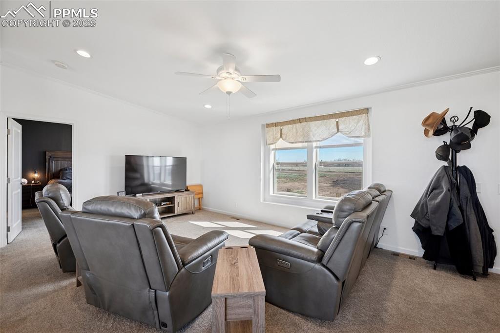 Image 14 of 34: Living room with carpet floors, ceiling fan, baseboards, and recessed light