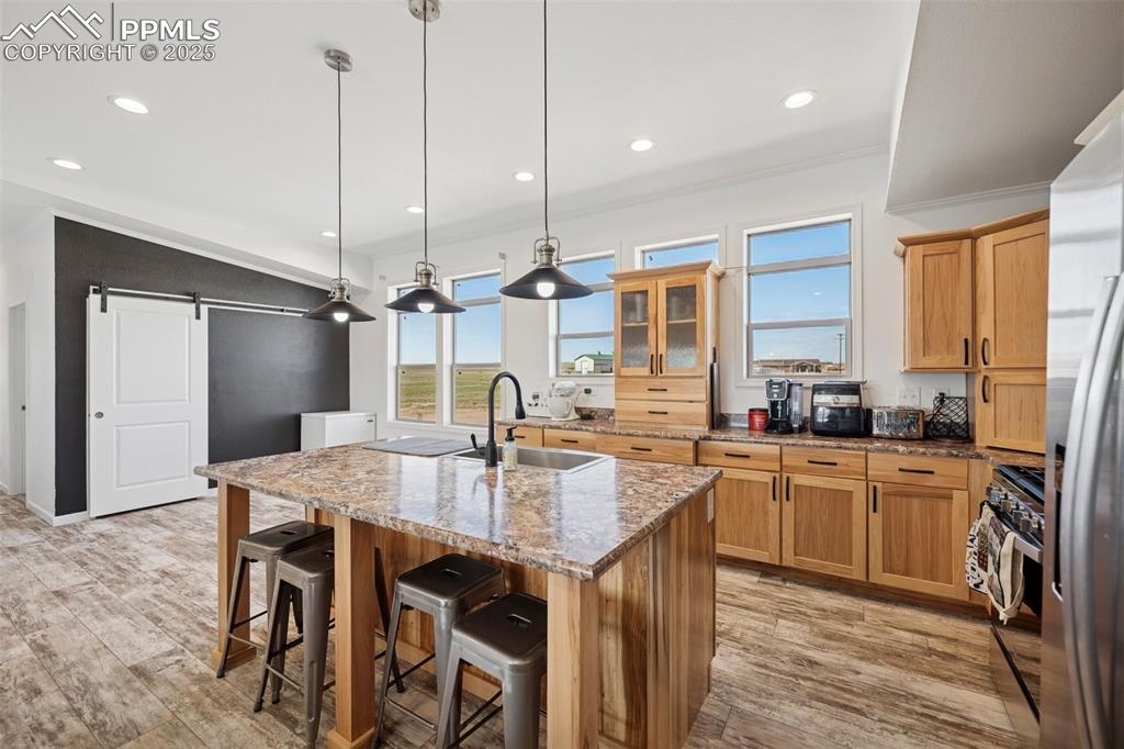 Image 18 of 34: Kitchen featuring appliances with stainless steel finishes, a barn door, a