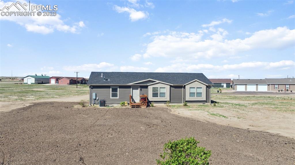 Image 2 of 34: View of front facade featuring a shingled roof and cooling unit