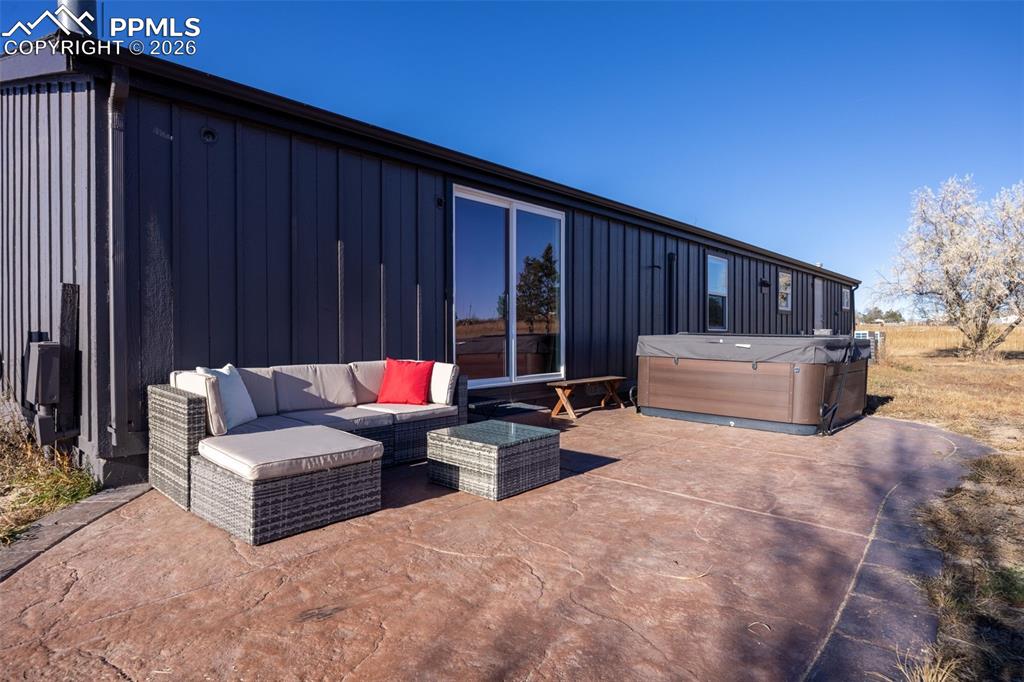 Image 32 of 49: View of patio / terrace with a hot tub and an outdoor living space