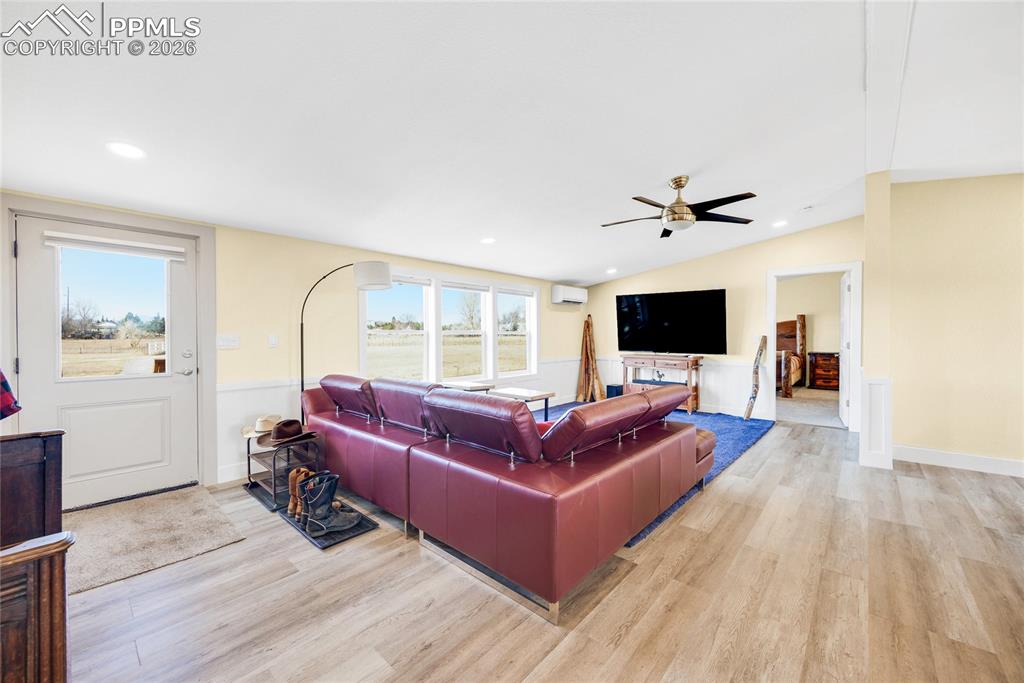 Image 6 of 49: Living room featuring light wood-style flooring, lofted ceiling, recessed l